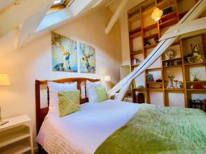 ein Schlafzimmer mit einem Bett und eine Treppe mit Regalen in der Unterkunft JO 2024 Grande Maison 10 voyageurs 30KM de paris in Cires-lès-Mello