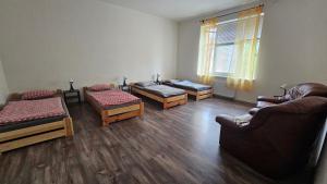una habitación con sofás y camas en una habitación en Ubytovaní U Dvora en Bohumín