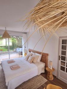 Schlafzimmer mit einem Bett mit einem großen Palmenblatt in der Unterkunft Chambre d'hôte BALI in La Roche-sur-Yon