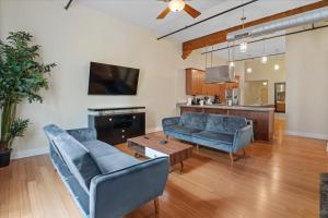 sala de estar con sofás azules y TV en Top Floor Loft In Downtown Indianapolis!!!, en Indianápolis
