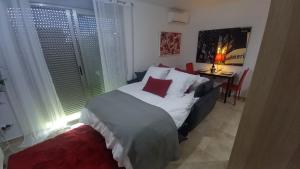 a bedroom with a bed and a desk and window at El estudio de las mariposas,sofa cama , cocina y baño in Partida de La Cañada
