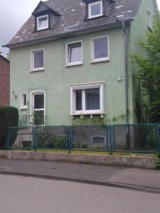 uma casa verde com uma cerca em frente em Aldo haus em Siegen