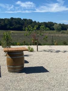 una mesa de madera sobre un barril en Villa climatisée avec piscine CHAUFFÉE au cœur du massif d'Uchaux , calme absolu !, en Mondragon