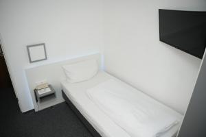 een kleine kamer met een bed en een televisie bij Weber Residenz in Mannheim
