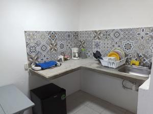 uma pequena cozinha com um lavatório e uma bancada em Hospedaje San Benito em San Cristóbal de Las Casas