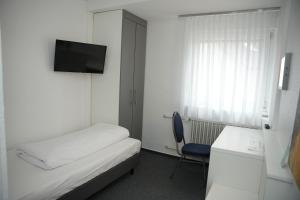 a room with a bed and a desk and a tv at Weber Residenz in Mannheim