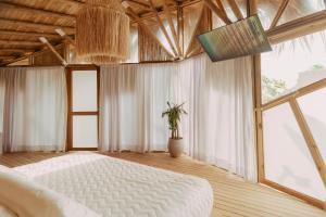 a bedroom with a white bed and a large window at JERUSALEMA BEACH GLAMPING in Tolú