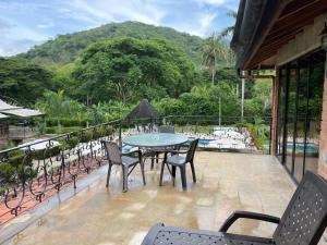 a patio with a table and chairs on a balcony at Casa Fuego in La Pintada