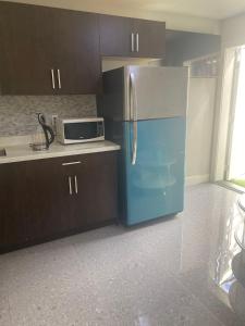 uma cozinha com um frigorífico azul e um micro-ondas em Panorama VistaVue Vancouver em Vancouver