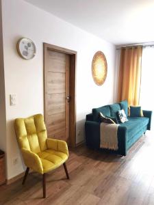 ein Wohnzimmer mit einem Sofa und einem Stuhl in der Unterkunft Apartament Olecko Centrum in Olecko