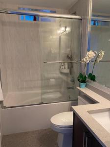 uma casa de banho com um chuveiro, um WC e um lavatório. em Panorama VistaVue Vancouver em Vancouver