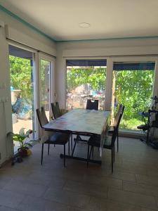 een eetkamer met een tafel, stoelen en ramen bij CHALET FRENTE AL MAR in Gandía
