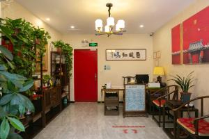 Cette chambre comprend une porte rouge, une table et des chaises. dans l'établissement Rong Hotel - Beijing Nanluoguxiang Branch, à Pékin