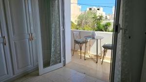 a door leading to a balcony with a table and chairs at Bensassi Urban Escape in La Marsa