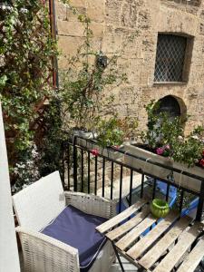 drewniana ławka na balkonie z kwiatami w obiekcie Real Fonderia b&b w mieście Palermo