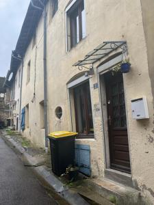 un edificio con un cubo de basura al lado de una calle en Chez Mathilde, maison de 90m2 pour 6 personnes, en Vaucouleurs