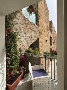 un balcón con una silla y algunas plantas y un edificio en Real Fonderia b&b, en Palermo