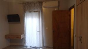 cortina blanca en una habitación con puerta en Room Breakfast, en Zarzouna