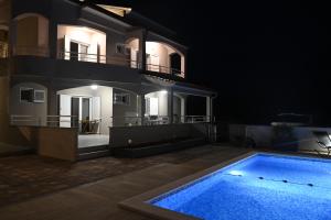 a house with a swimming pool in front of it at night at Villa Gehl in Lopar