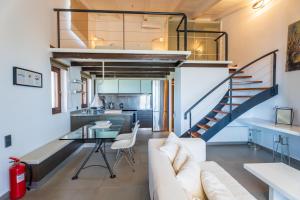 uma sala de estar com um sofá, uma mesa e uma escada em Krinos Suite-Magnificent Sea view em Hersonissos