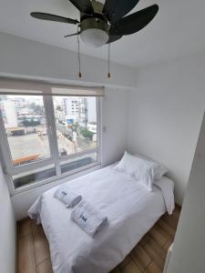 利馬的住宿－Acogedor 2BR Miraflores - Tovar，卧室配有白色的床和吊扇