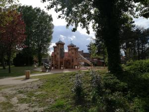 a large brick building in a park with a tree at Appartement 50m² centre-ville in Dunkerque