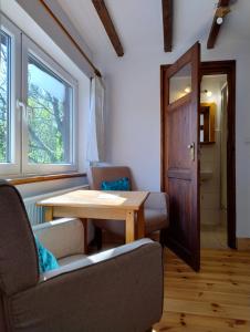 a living room with a table and chairs and a door at Podołynia in Dwernik