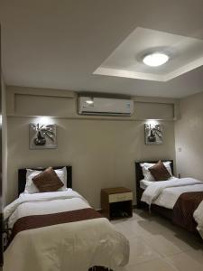 una camera con due letti e un condizionatore d'aria di منتجع درة الشرق للعائلات a Dammam