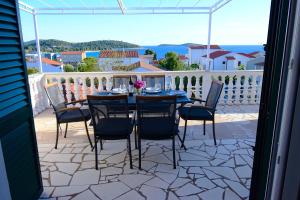 un patio con tavolo e sedie su un balcone di Apartmani Barba a Rogoznica (Rogosnizza)