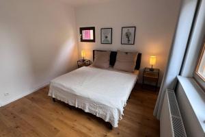 ein Schlafzimmer mit einem weißen Bett und zwei Lampen in der Unterkunft Design Apartment im alten Schloss Deidesheim in Deidesheim