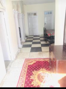 a hallway with a rug on the floor and two doors at Marry House in Murree