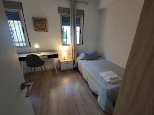 1 dormitorio con 2 camas, escritorio y escritorio en Apartamento Celia, en Sevilla
