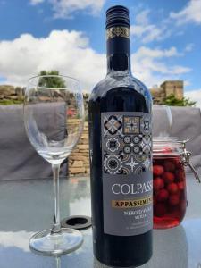 eine Flasche Wein neben einem Weinglas in der Unterkunft Beautiful countryside cottage, sleeps 6, dogs welcome in Halifax