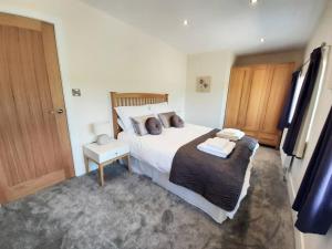 ein Schlafzimmer mit einem großen Bett und einer Holztür in der Unterkunft Beautiful countryside cottage, sleeps 6, dogs welcome in Halifax