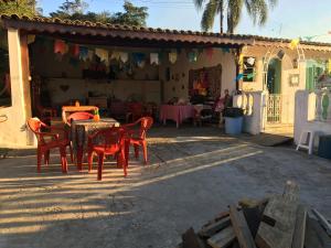 d'une terrasse avec des chaises rouges et une table avec dans l'établissement Cantinho Romântico e Encantador, à Mairiporã
