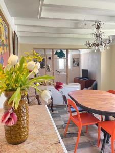 a dining room with a table and a vase with flowers at Logement à castex in Castex