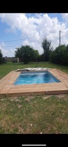 a small swimming pool with a wooden deck at Logement à castex in Castex