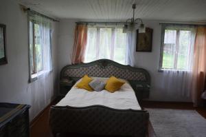 ein Schlafzimmer mit einem Bett mit gelben Kissen in der Unterkunft Inn Kunai in Anykščiai