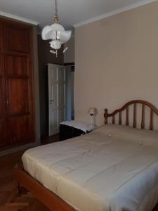ein Schlafzimmer mit einem großen weißen Bett und einem Kronleuchter in der Unterkunft Mendoza - Casa Cardozo in Guaymallen