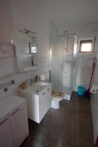 un bagno bianco con un water e un lavandino di Apartmani Barba a Rogoznica (Rogosnizza) Altre 27 foto