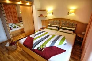 a bedroom with a bed and a large mirror at See-Apartments Kärntnerhof in Weissensee