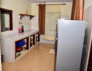 a kitchen with a white refrigerator and a counter at Karura and friends airbnb (affordable) in Ukunda