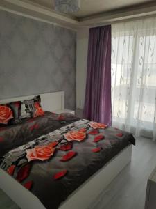 a bedroom with a bed with flowers on it at Korallia Penthouse in Mamaia Nord