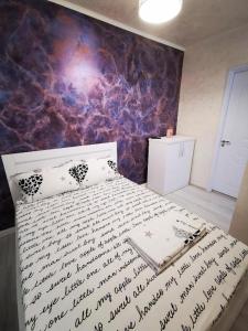 a bedroom with a bed with a wall covered in signatures at Korallia Penthouse in Mamaia Nord