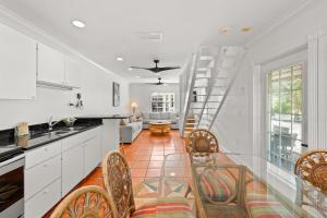 una cocina con armarios blancos y una escalera de caracol en Tropic Isle At Anna Maria Island Inn, en Bradenton Beach