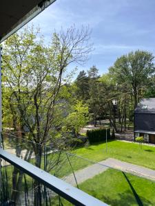 a balcony with a view of a yard at Apartamentai-studija Palangos kopos in Palanga