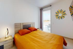 ein Schlafzimmer mit einem großen Bett mit orangefarbenen Kissen in der Unterkunft Luxueux appartement bord de plage, terrasse et spa in Valras-Plage