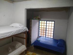 een kamer met 2 stapelbedden en een raam bij Clandestino Hostal in Gigante