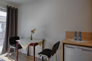 um quarto com uma mesa com cadeiras e um vaso de flores em See Hotel Karlslust Chalets em Storkow