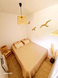 een slaapkamer met een bed en vogels aan de muur bij Le bord de mer pour 4 personnes in Six-Fours-les-Plages
